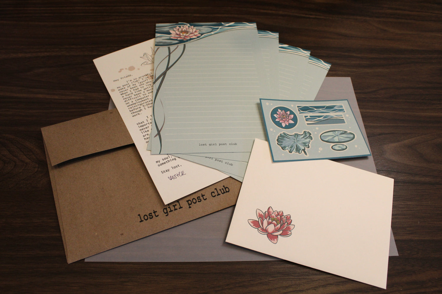Collection of stationery items including envelopes and letterheads on a wooden surface.